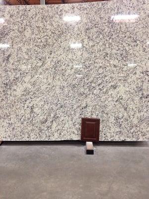 The ashen white slab of granite we chose and a sample of our chocolate colored kitchen cabinet that the granite will sit on.