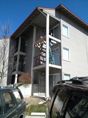 Repairing a porch on an apartment building.