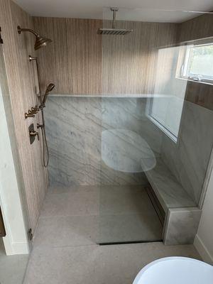 master bath lower slab with wood panel porcelain tide and limestone on floor