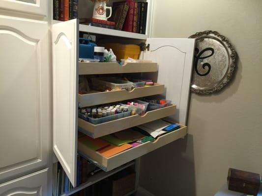 A TV area converted with doors and pullouts into a art supply station.