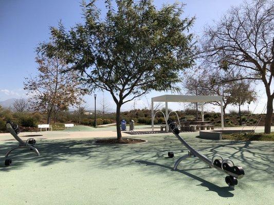 Two seesaws, one trampoline built into the ground, two disc swings