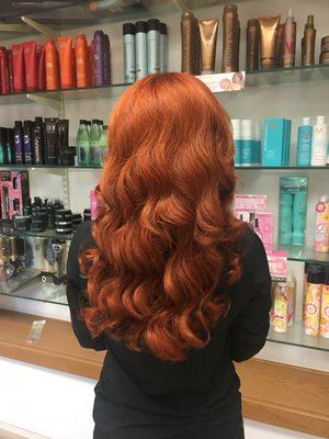 A finished product incorporating a high definition red copper permanent hair color , hair extensions ,and wand wave curls