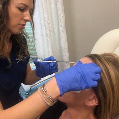 Emilie, ARNP injecting Botox to help relax this patients wrinkles.