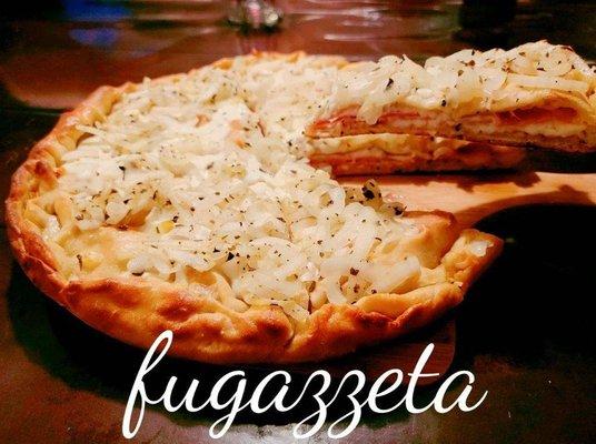 Fugazzeta is a Argentinian treat that is a double-crusted version of fugazza, stuffed with cheese, Ham and topped with the same sweet onions