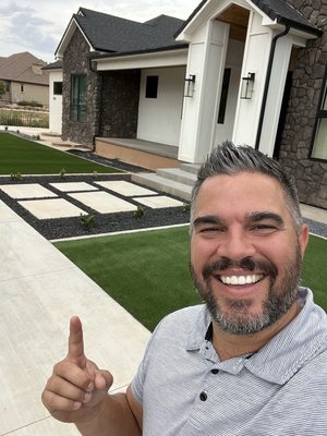 Installation of Artificial Turf with concrete curbing and decorative rock with plants and drip.