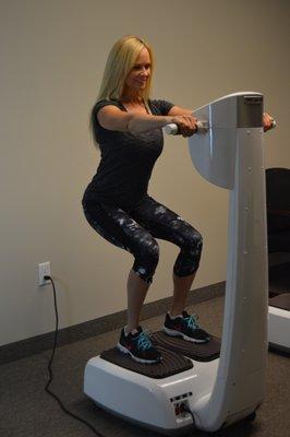 A client using the vibration plates after her 20 minute light therapy treatment. 16 paddles are used to treat multiple parts of your body.