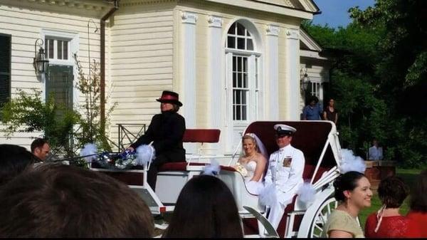 The bride and the father of the bride being brought in by horse and carriage