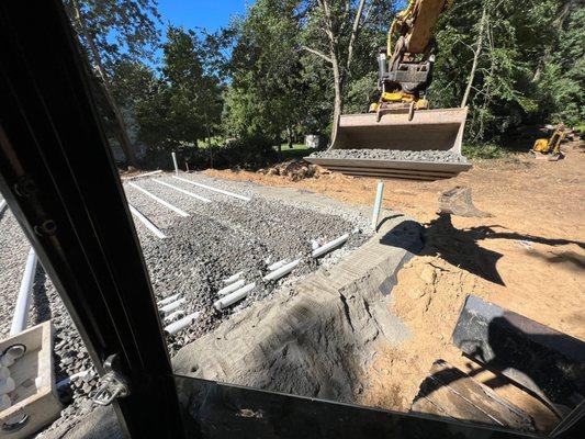 Stone is placed on the septic laterals to hold them in place and protect them for backfill