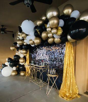 Shimmer and sequin wall with balloon garland and metal tables