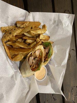 Teriyaki chicken wrap with lettuce, tomatoes, and pineapple and a side of fries and fry sauce