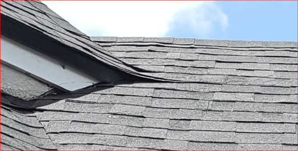 Buckled shingles and shingle damage by roofers