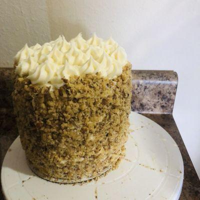 Carrot tall cake with cream cheese frosting coved with walnuts