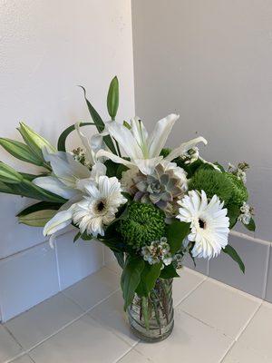 White and green medium vase arrangement with succulent and accent flowers.