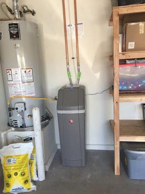 Water softener with lines running to main water supply.