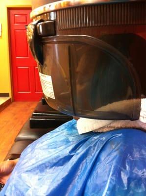 Snuck a picture of a woman getting her hair dried. In the cool dryer section.