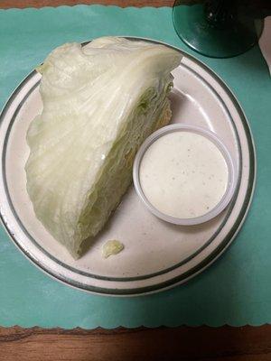 Lettuce wedge salad with ranch in the side.