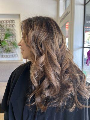 Balayage of natural golds for her deep brown hair to lighten it with a "lived in" look. Layers to create movement.