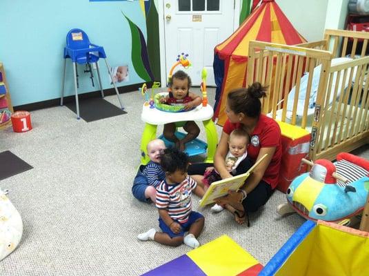 Ms. Nathalia captivating the infants with a book in our Early Beginners suite