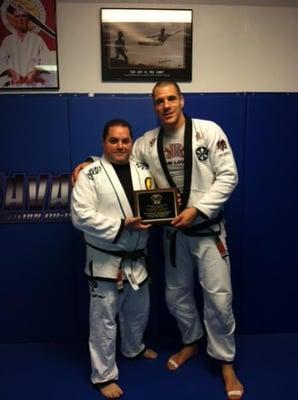 Professor Sav receiving award from Rafael Lovato Jr for "Instructor of the year"