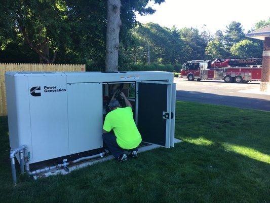 Routine maintenance on a Cummins backup generator.