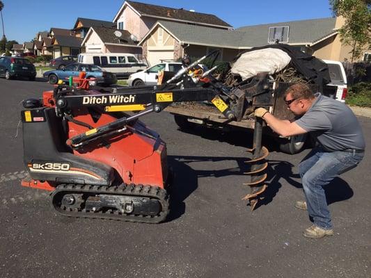 Vince fitting the drill and auger attachment to his new ditch witch