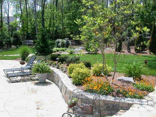 Landscaped courtyard above stone patio and retaining wall.