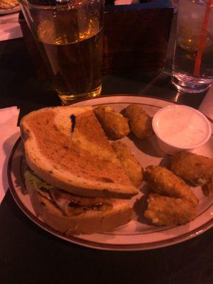 Half of a pub club sandwich with a side of jalapeño poppers