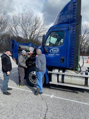 Instructor and students of Sage Truck Driving School going over checklists.