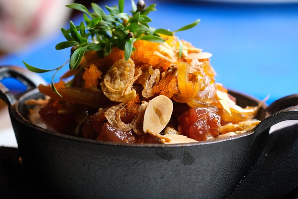 Cast Iron Poke Bowl with Yellofin Tuna, sweet and spicy sauce, toasted coconuts and almonds, shallots, masago, and micro cilantro