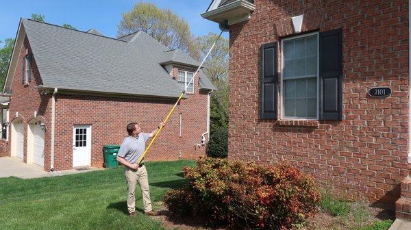 Servicing the exterior of a residential home for quarterly pest control.