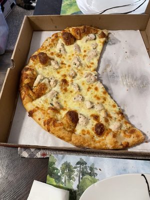 A white pizza with chicken and garlic