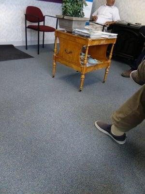 Dirty waiting room with old worn out furniture.