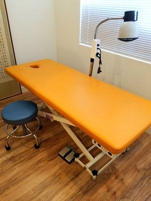 Acupuncture table with infrared heat lamp to help circulation