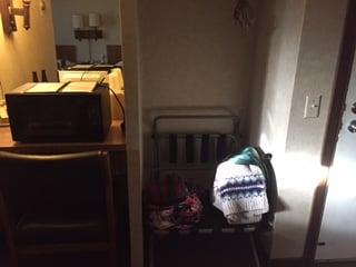 luggage stand, desk (with microwave) and closet.