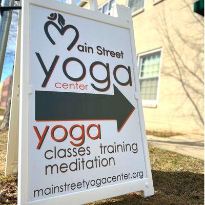 Main Street Yoga Center sandwich board sign outside the entry door on Main Street