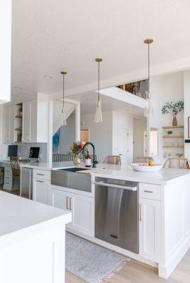 View into living area. Appliances and island sink. Desk area.