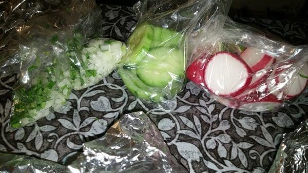 To go orders come with bags with cilantro and onion, cucumber, and radishes.