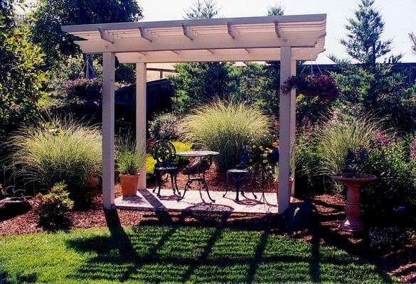 Three tiered redwood arbor painted white provides a quiet retreat