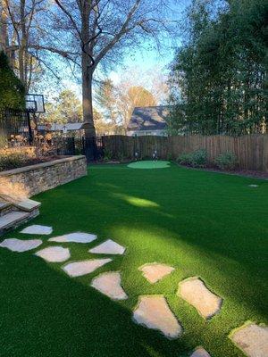 Backyard with putting green installed by Southern Turf Co.