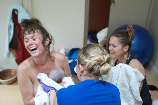 Sharon and Kara support an ecstatic mother moments after birth