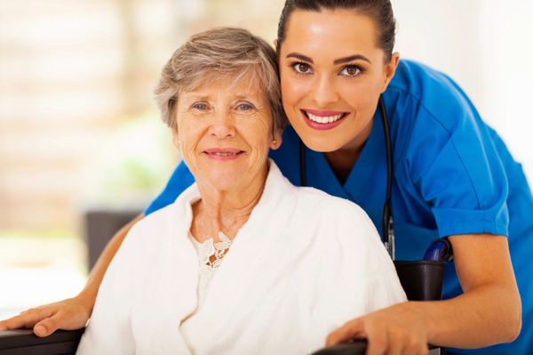 Young woman caring for a senior both smiling