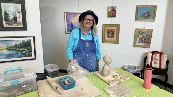 Gallery Manager Darrci Robertson giving a demonstration of clay sculpture.