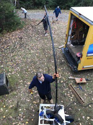 Clayton putting the pipe, wire and pump back down in the well.