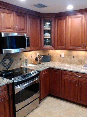 This kitchen with raised panel door and drawers, stained Cherry, with satin laquer finish