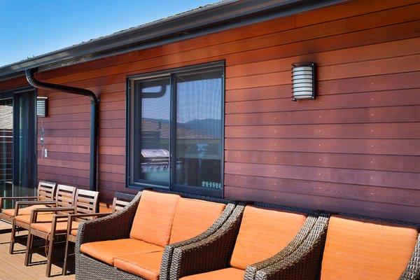 This incredibly inviting outdoor space includes modern lighting and is framed in a richly textured, prestained red western cedar channel.