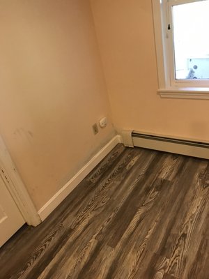 Install new laminate floor, fix drywall, install new baseboard