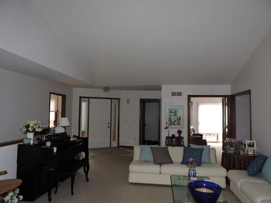 The living room viewed from the fireplace to the entry foyer.