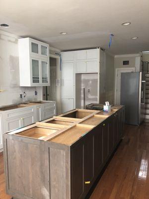 White shaker wall cabinets and espresso shaker island.