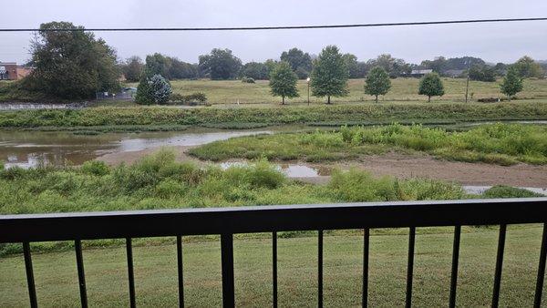 View of the walking/running path on the other side of the river from the balcony.