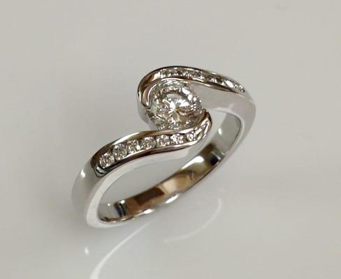 Ladies white gold bezel set diamond ring accented with channel set diamonds Ginis Goldsmiths, Midland, MI